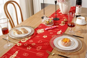 Detail of red festive table runner with golden lantern and cloud patterns in a dining setting