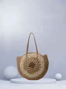 Detailed close-up of circular woven paper straw bag with brown leather shoulder straps