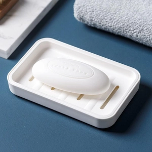 Minimalist white double-layer plastic soap dish with drainage holes on dark blue background