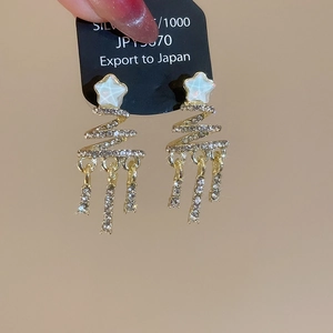 Detailed view of golden Christmas tree earrings with sparkling diamonds and long tassels