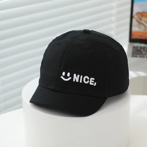 Close-up detail of 'NICE,' smile embroidery on high-quality black cotton twill baby cap