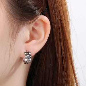 Gros plan de boucles d'oreilles argentées style bracelet de montre sur modèle