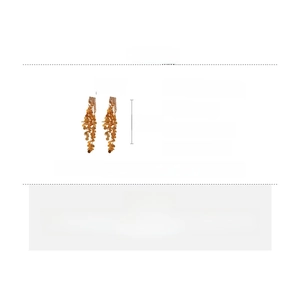 Detail view of long tassel earrings with golden sequins and zircon in copper and silver