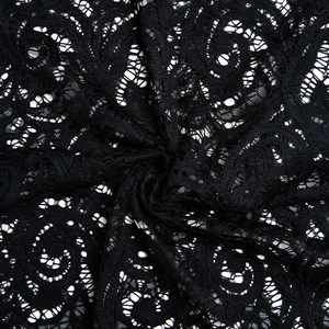 Close-up detail of sheer black floral lace fabric with intricate scrollwork and mesh texture