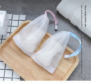 Close-up of pink and blue drawstring foaming nets with fine white nylon mesh on a tray