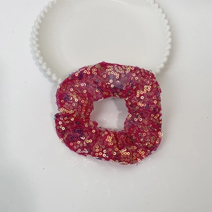Detailed shot of pink mesh hair scrunchie with sparkling gold and colored sequins