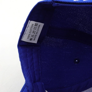 Detail shot of the internal white cotton care label on a blue flat brim baseball cap