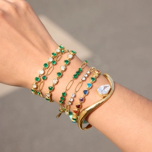 Stack of 18K gold-plated stainless steel tennis bracelets with green and white zircons