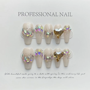Press-on nails in long coffin shape with nude beige base and heart-shaped gemstone
