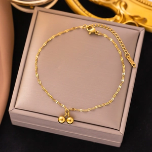 Gold titanium anklet with twisted chain and double bead charms on a display box
