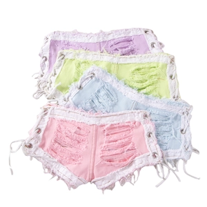 Detalle de shorts vaqueros desgastados con bordes deshilachados y cordones laterales