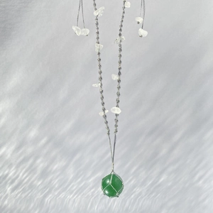 Pendentif en jade vert fait main avec filet argenté sur un cordon de collier tressé
