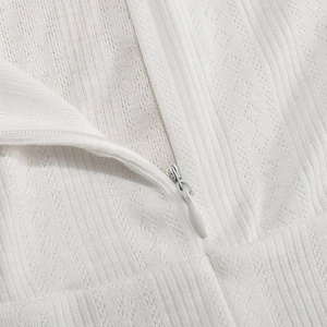 Macro detail of the invisible zipper and white textured jacquard fabric on the dress