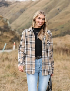 Classic light brown plaid shirt with black and white checks in an autumn outdoor setting