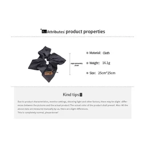 Detail showing soft cloth hair tie dimensions and texture with small leather label