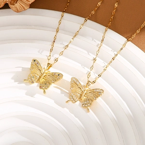 Macro detail of gold butterfly necklaces with shimmering zircon stones on a white stand