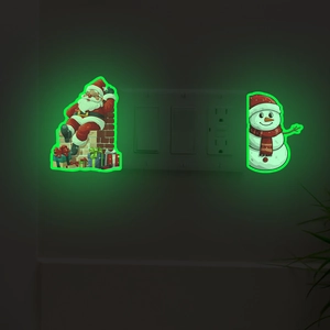 Glow-in-the-dark Santa and snowman stickers glowing green around a wall light switch