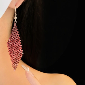 Gros plan de boucles d'oreilles rose en strass avec un design en maille losange