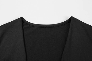Close-up of black knitted dress showing layered V-neckline and fine stitching details