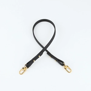 Detail of black lychee grain leather shoulder strap with golden metal swivel hooks