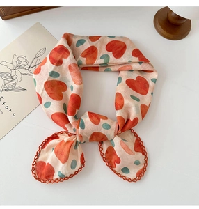 Detail of floral linen neckerchief featuring orange heart patterns and lace edging