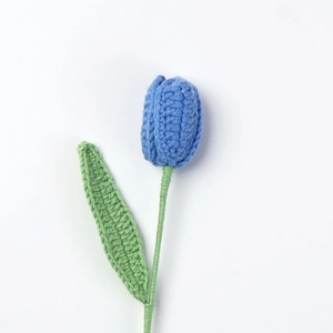 Handgestrickte blaue Tulpe mit grünem Stiel auf weißem Hintergrund als Geschenk