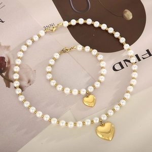 Détail d'un ensemble de bijoux en perles et perles dorées avec pendentifs en cœur