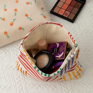 Detailed view of floral corduroy makeup bags showing storage capacity and zipper closure