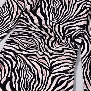 Detail of zebra print dress featuring artistic pink hues and side ruched fabric textures