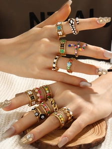Detail of 18k gold plated fashion ring set featuring colorful enamel clover and snake designs