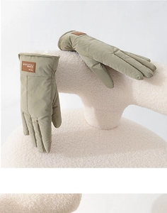 Close-up of olive green winter gloves with windproof fabric and leather Snow Gloves label