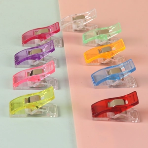 Set of colorful plastic sewing clips for fabric quilting and DIY crafts on dual tone background