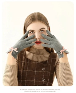 Vue détaillée de gants thermiques gris foncé avec un élégant nœud en satin rose au poignet