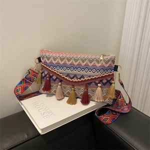 Detail of bohemian woven crossbody bag with colorful tassels and a wide jacquard strap