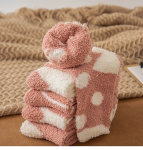 Close-up of thick pink coral fleece socks with polka dot pattern for winter comfort