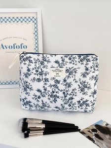 Détail macro d'une trousse à maquillage matelassée aux motifs floraux bleus vintage