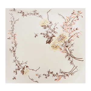 Close-up of elegant floral silk scarf with yellow and brown flowers on beige fabric