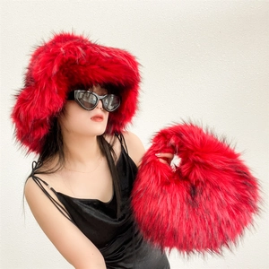 Close-up of bright red faux fur bucket hat and matching plush handbag set for winter
