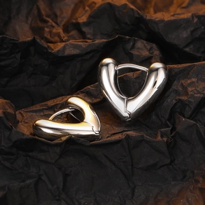 Polished silver heart-shaped vintage earrings on black background in high detail