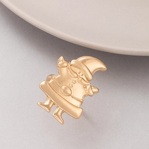 Macro detail of golden Santa Claus holiday brooch with matte and polished alloy textures