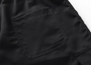 Detail of rear pocket stitching and woven fabric texture on black cargo shorts