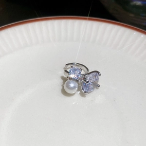 Detail of silver open ring featuring sparkling clear zircons and a lustrous white pearl