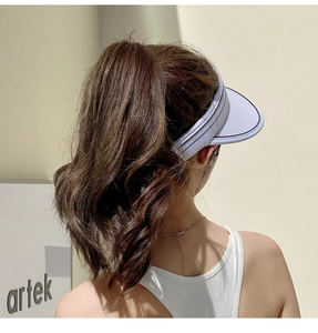 Close-up of a white visor hat with black stripe trim showing breathable texture and fit