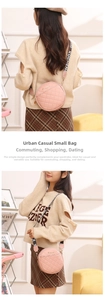 Detail of pink round quilted crossbody bag with wide printed strap and golden logo