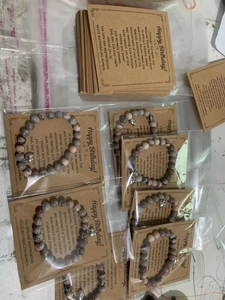 Macro view of 8mm pink zebra stone bead bracelet with heart charm and birthday card