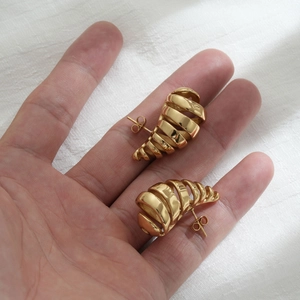 Orecchini a goccia in oro con design a spirale cava mostrati sulla mano