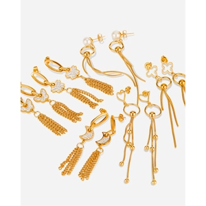 Detail of gold-plated drop earrings featuring tassels with butterfly and pearl accents
