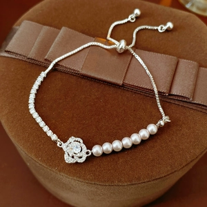 Detailed macro view of silver flower bracelet with pearls and adjustable sliding buckle
