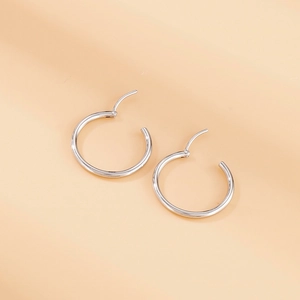 Polished silver stainless steel round hoop earrings shown in a minimalist static shot