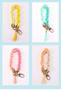 Macro view of colorful acrylic chain keychains with suede tassels and gold lobster clasps